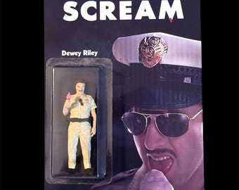 May include: A packaged action figure of Dewey Riley from the movie "Scream." The figure is in a clear plastic case, and the packaging features the word "SCREAM" in large white letters. The figure is wearing a tan police uniform and holding a pink ice cream cone.