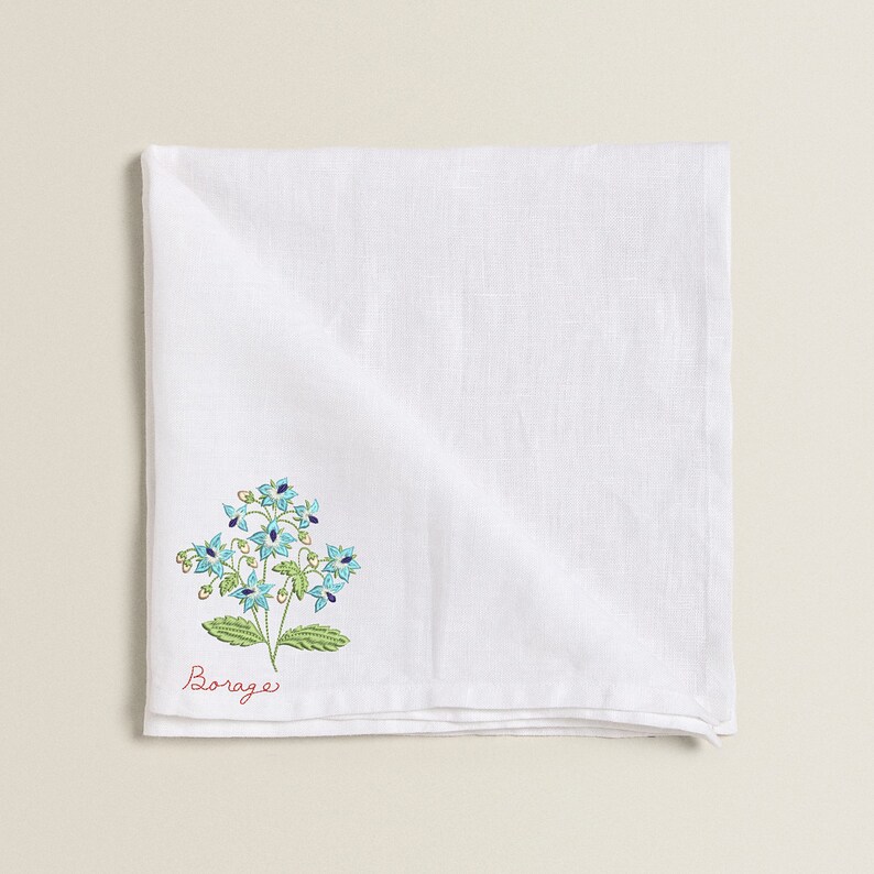 Pu&ograve; includere: Asciugamano da t&egrave; in lino bianco con fiori ricamati blu e verdi e la parola "Borage" in rosso.