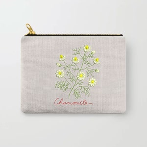 Pu&ograve; includere: Una pochette con cerniera in tela bianca con un motivo di camomilla ricamato in verde e giallo e la parola "Chamomile" in corsivo rosso.