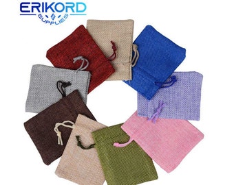 Pode incluir: Dez pequenas bolsas de cordão de juta em várias cores, incluindo vermelho, azul, cinza, marrom, bege, rosa e verde. As bolsas estão dispostas em círculo sobre um fundo branco.