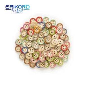 Puede incluir: Un conjunto de botones de madera coloridos en varios tonos pastel, incluyendo rojo, rosa, verde, azul y beige. Cada botón tiene cuatro agujeros y un centro de color claro. Los botones están dispersos sobre un fondo blanco. El logotipo "ERIKORD SUPPLIES" está en la esquina superior izquierda.