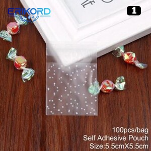 May include: 100 clear self-adhesive pouches with a white polka dot pattern. The pouches are 5.5 inches by 5.5 inches.