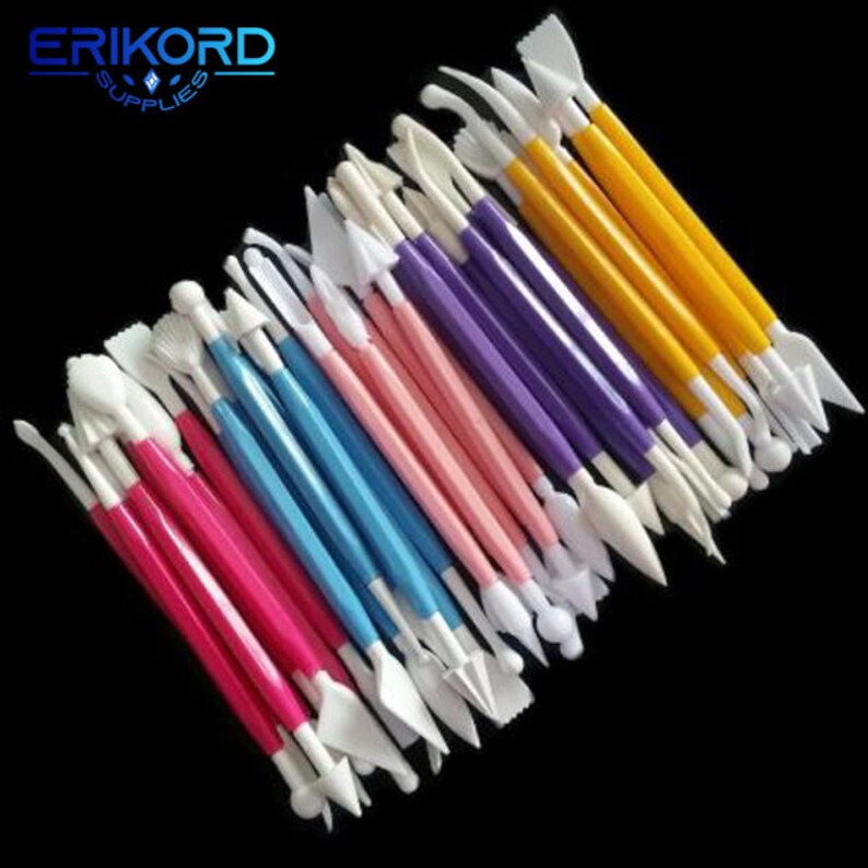 May include: A set of 20 colorful plastic cake decorating tools with various shapes and sizes. The tools are arranged in a fan shape with the handles facing up. The tools are white, yellow, pink, blue, and purple. The tools are labeled "ERIKORD SUPPLIES".