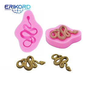 Puede incluir: Dos moldes de silicona rosa para hacer joyas de resina o arcilla polimérica en forma de serpiente. Los moldes se muestran con dos amuletos de serpiente de color dorado.