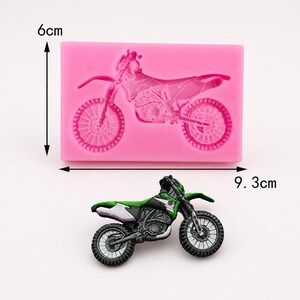 May include: A pink silicone mold in the shape of a motorcycle, measuring 9.3 cm long and 6 cm high. A green, black, and white motorcycle is placed below the mold. The motorcycle has detailed features.