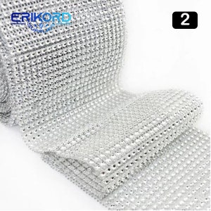 May include: A roll of silver rhinestone trim, with a grid pattern of small, clear rhinestones. The trim is approximately 1.5 inches wide and is perfect for adding sparkle to crafts, clothing, and home decor.