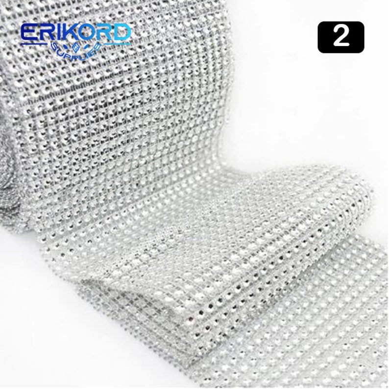 May include: A roll of silver rhinestone trim, with a grid pattern of small, clear rhinestones. The trim is approximately 1.5 inches wide and is perfect for adding sparkle to crafts, clothing, and home decor.