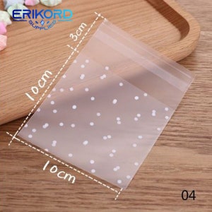 May include: Clear plastic bag with a white polka dot pattern. The bag measures 10 inches by 10 inches and 3 inches tall.