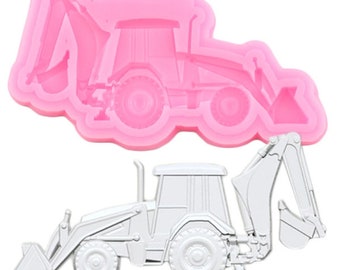 Puede incluir: Molde de silicona rosa de una excavadora de retroexcavadora. El molde se utiliza para crear una decoración de pastel u otras decoraciones comestibles.