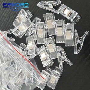 May include: A clear plastic bag filled with clear plastic clips with a silver metal spring. The clips are designed to hold fabric together.
