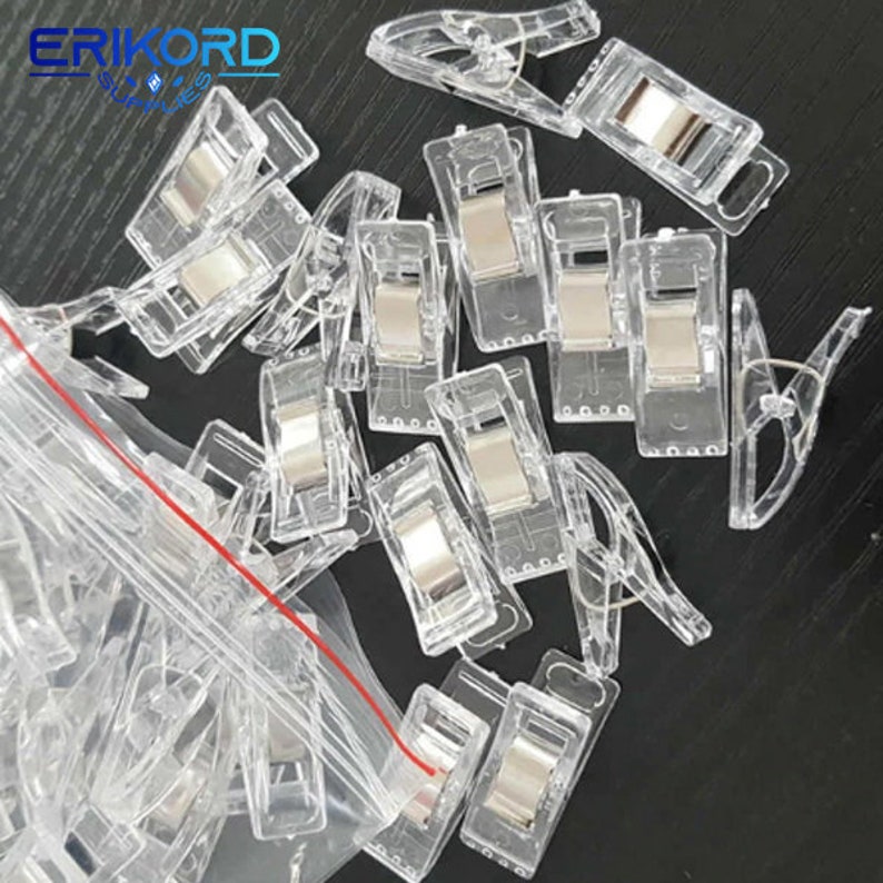 May include: A clear plastic bag filled with clear plastic clips with a silver metal spring. The clips are designed to hold fabric together.