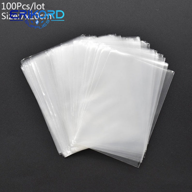 Op de afbeelding: Een stapel van 100 doorzichtige plastic zakjes, perfect voor het verpakken van kleine voorwerpen. De zakjes zijn allemaal even groot en gemaakt van dun, transparant plastic. 100Pcs/lot Maat 7x10cm.