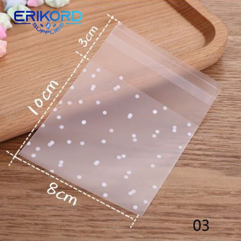 May include: Clear plastic bag with a white polka dot pattern. The bag measures 8 inches by 3 inches. The bag is labeled "03".
