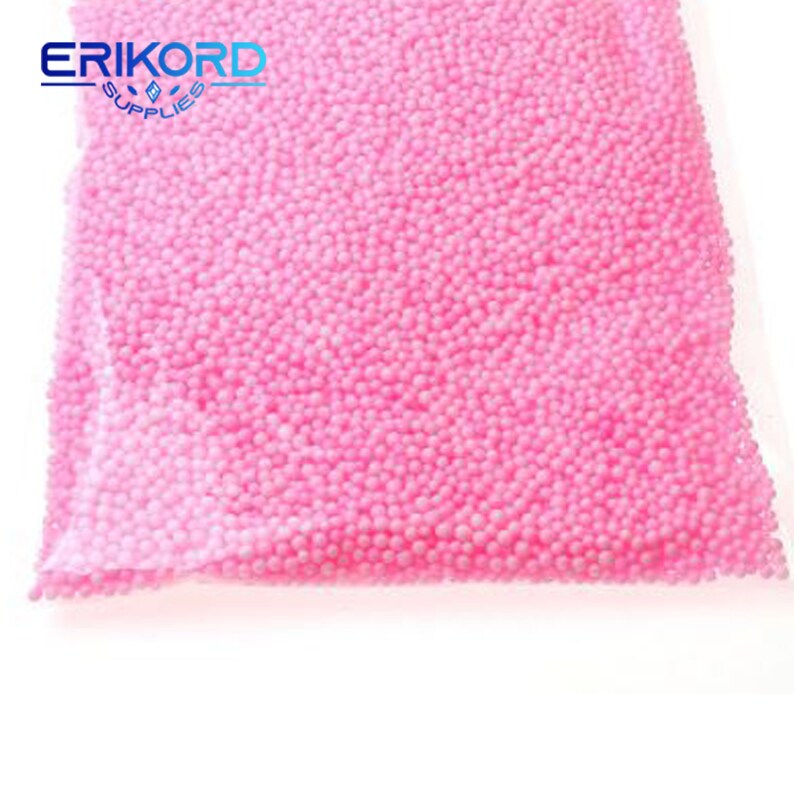 May include: A close-up of a bag filled with pink foam balls. The bag is clear plastic and the foam balls are small and round.