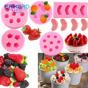 Può includere: Un set di stampi in silicone rosa per cuocere diverse forme di frutta, tra cui fragole, ananas e agrumi. Gli stampi sono mostrati con prodotti da forno finiti, tra cui una torta alle fragole e coppette di gelato con guarnizioni di frutta.