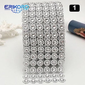 May include: Silver rhinestone trim with a fringe design. The trim is approximately 1 inch wide and is perfect for adding sparkle to crafts, clothing, and home decor.