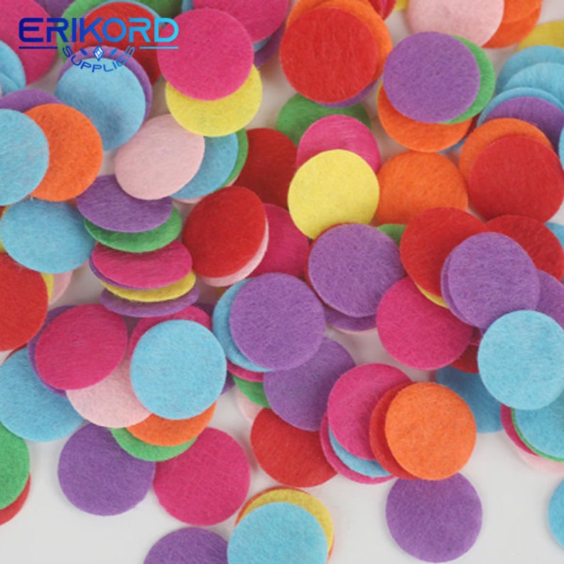 Op de afbeelding: Een grote stapel kleurrijke viltcirkel in verschillende tinten rood, oranje, geel, groen, blauw, paars en roze. De cirkels zijn ongeveer 2,5 cm in diameter.