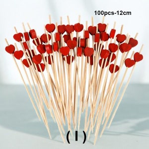 May include: A bunch of 100 wooden skewers with red heart-shaped toppers. The skewers are 12 cm long.