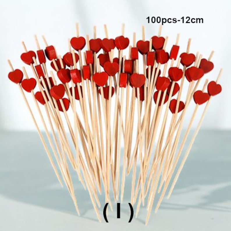 May include: A bunch of 100 wooden skewers with red heart-shaped toppers. The skewers are 12 cm long.