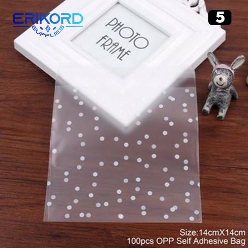 May include: 100 clear plastic self-adhesive bags with white polka dots. The bags are 14 inches by 14 inches.