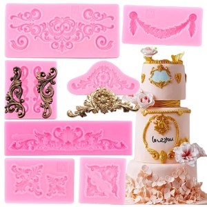 May include: Set of 8 pink silicone cake decorating moulds with intricate floral and scroll designs. The moulds are arranged on a white surface with a decorated cake in the background.