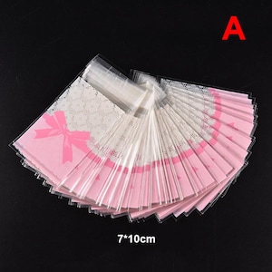 50 Stück 7 * 10 cm / 7 * 7 cm Rosa Schleife Kunststoff Opp Taschen Selbstklebende Plastiktüten für Kekse Snacks Süßigkeiten und Kekse Hochzeit Taufe Party Tasche