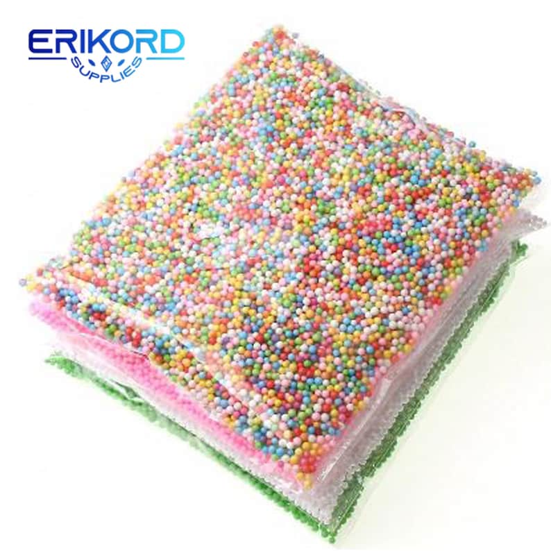 May include: A close-up of a stack of clear plastic bags filled with colorful foam balls. The bags are stacked on top of each other, with the top bag being the most visible. The foam balls are small and round, and they are a variety of colors, including red, orange, yellow, green, blue, purple, and white.