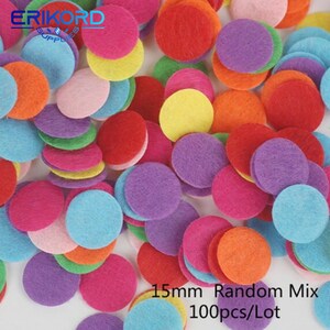 Op de afbeelding: Een stapel van 100 kleurrijke viltcirkel, elk met een diameter van 15 mm. De cirkels zijn in verschillende kleuren, waaronder rood, oranje, geel, groen, blauw, paars en roze. 15mm Random Mix 100 stuks/Lot