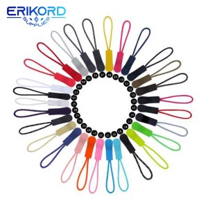 Puede incluir: Un conjunto de 27 tiradores de cremallera de colores dispuestos en círculo. Cada tirador tiene un color diferente y un número impreso en él. Los tiradores de cremallera están hechos de un material suave y flexible.