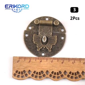 May include: Two antique brass butterfly-shaped clasps with ornate floral designs. The clasps are approximately 2 inches in diameter and have a hinged latch.