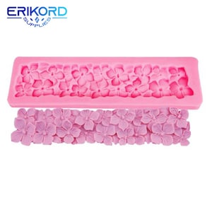 May include: Pink silicone mold with a design of a row of small flowers. The mold is shown with a row of pink fondant flowers made with the mold.