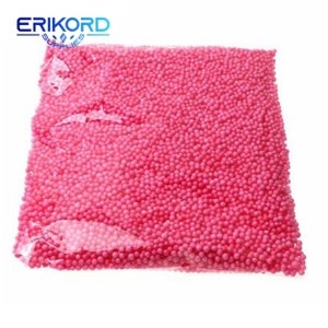 May include: A close-up of a large bag filled with pink foam balls. The bag is clear plastic and the balls are small and round.