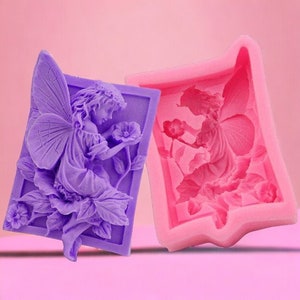 May include: Two silicone moulds for making fairy-themed crafts. The moulds are purple and pink and feature a fairy with wings and flowers.