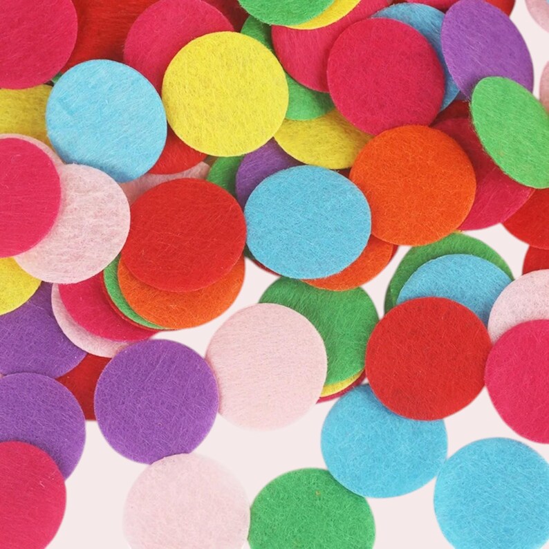 Op de afbeelding: Assortiment van kleurrijke vilt cirkels in verschillende maten. De cirkels zijn in tinten rood, roze, blauw, groen, geel en paars.