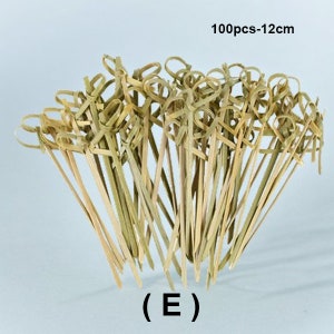 May include: A bundle of 100 natural bamboo skewers with a knotted loop at the top, measuring 12 inches in length.  The skewers are ideal for appetizers, fruit skewers, and other culinary creations.  (E)