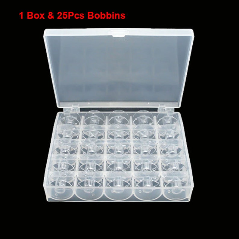 May include: A clear plastic box with 25 clear plastic bobbins for storing sewing thread. The box has a lid that opens to reveal the bobbins.