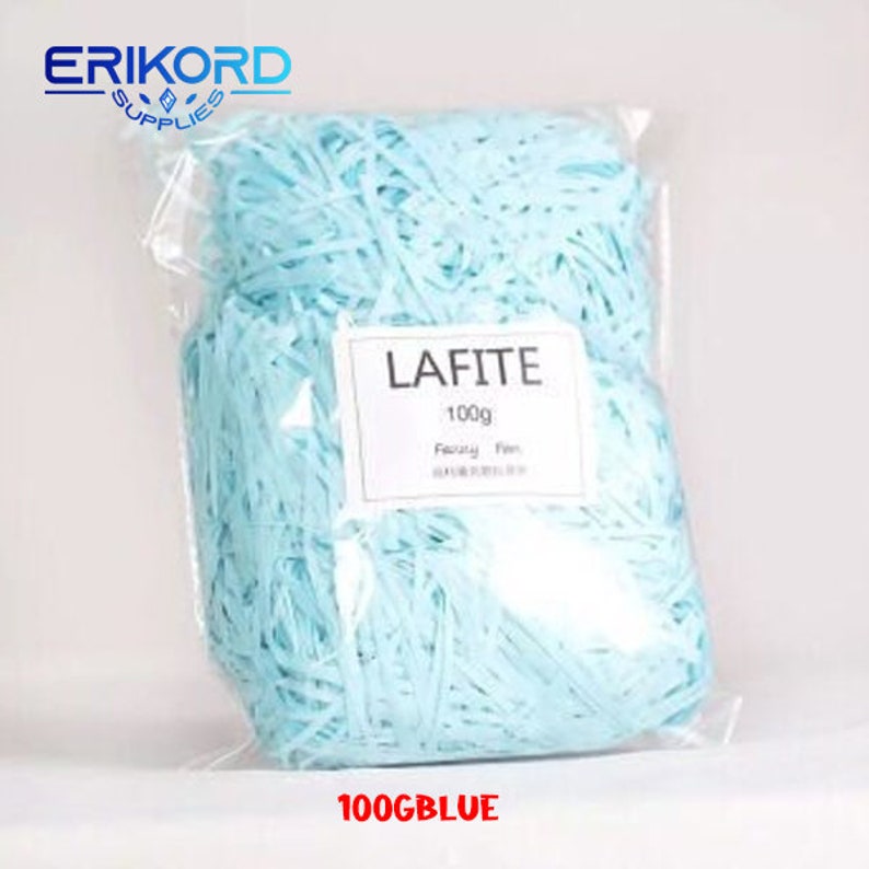 May include: A clear plastic bag filled with light blue shredded paper. The bag has a white label that says "LAFITE 100g Fancy Paper". The bag is labelled "100GBLUE" at the bottom.