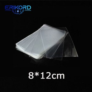 May include: A stack of clear plastic bags, 8 by 12 centimetres in size.