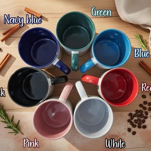 A collection of seven colorful mugs arranged in a circular pattern on a wooden surface, with cinnamon sticks and coffee beans scattered around.