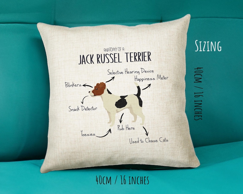 May include: A white and beige pillow with a Jack Russel Terrier illustration and the text "Anatomy of a Jack Russel Terrier". The illustration shows the dog's body parts labeled with humorous names like "Blinkers", "Snack Detector", "Selective Hearing Device", "Happiness Meter", "Rub Here", "Toesies", and "Used to Chase Cats". The pillow is 16 inches by 16 inches.