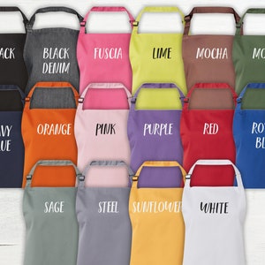 May include: A set of 15 colorful aprons with different colors and text. The colors include black, denim, fuchsia, lime, mocha, moss, navy blue, orange, pink, purple, red, royal blue, sage, steel, sunflower, and white.