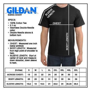Op de afbeelding: Een zwart t-shirt met een maattabel van Gildan. De tabel bevat metingen voor borst, lichaamslengte en mouwlengte in inches. Specificaties omvatten 100% katoen en een dubbele naadkraag.