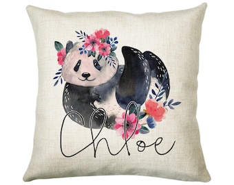 May include: A white pillow with a black and white panda bear wearing a pink and blue flower crown. The name "Chloe" is written in cursive below the panda.