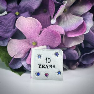 Carte souvenir traditionnelle en aluminium du 10e anniversaire de mariage personnalisée. Très petites initiales et date miniatures en cristal