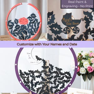 May include: A circular guest book frame featuring a clear center filled with small black wooden bat cutouts. The frame has a red or purple border with silver hardware. Text includes "Maisy's Baby Shower" and "Lauren & Alex October 15, 2024".