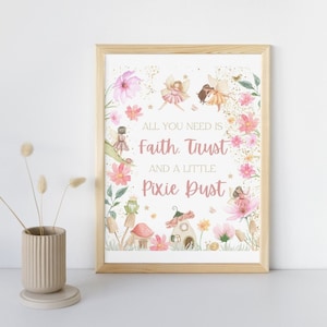 Puede incluir: Una impresión enmarcada con un tema de hadas. La obra de arte presenta hadas, flores y el texto "All you need is Faith, Trust, and a little Pixie Dust." El marco es de madera clara, y la paleta de colores es rosa y verde.