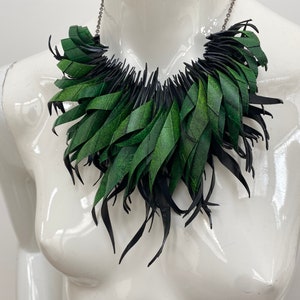 Green statement necklace, upcycled bicycle inner tube jewelry on a white mannequin