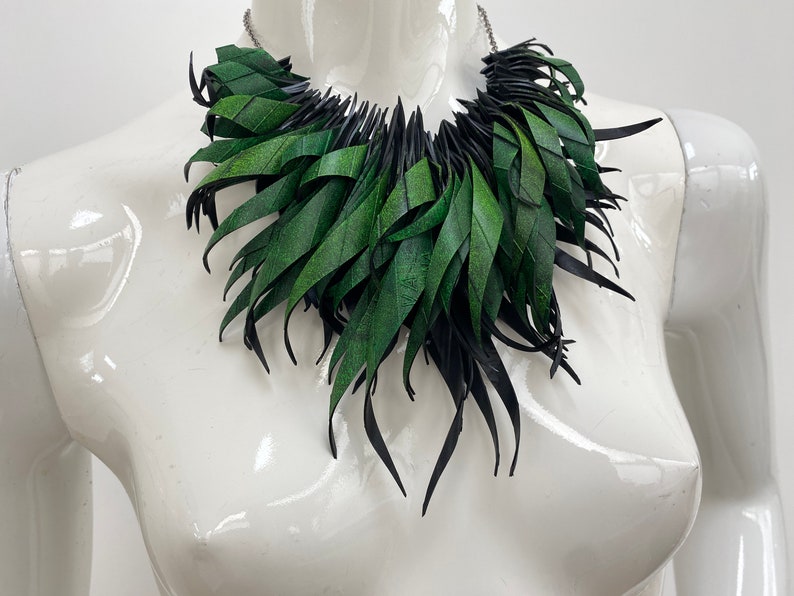 Green statement necklace, upcycled bicycle inner tube jewelry on a white mannequin
