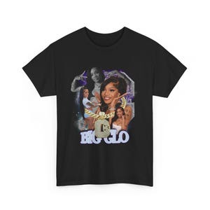 Puede incluir: Camiseta negra con un diseño de collage que presenta un retrato central de una mujer con una cadena de oro. El texto "BIG GLO" se muestra en una fuente azul claro debajo del retrato. El diseño incluye otras imágenes y un fondo morado.