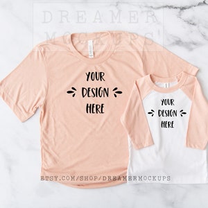 May include: Two peach-colored t-shirts, one short-sleeved and one long-sleeved with a white baseball-style sleeve, on a white marble background. The text "YOUR DESIGN HERE" is printed on both shirts.